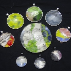 PENDANTS AND A PAPERWEIGHT WITH HANDMADE COLLAGE